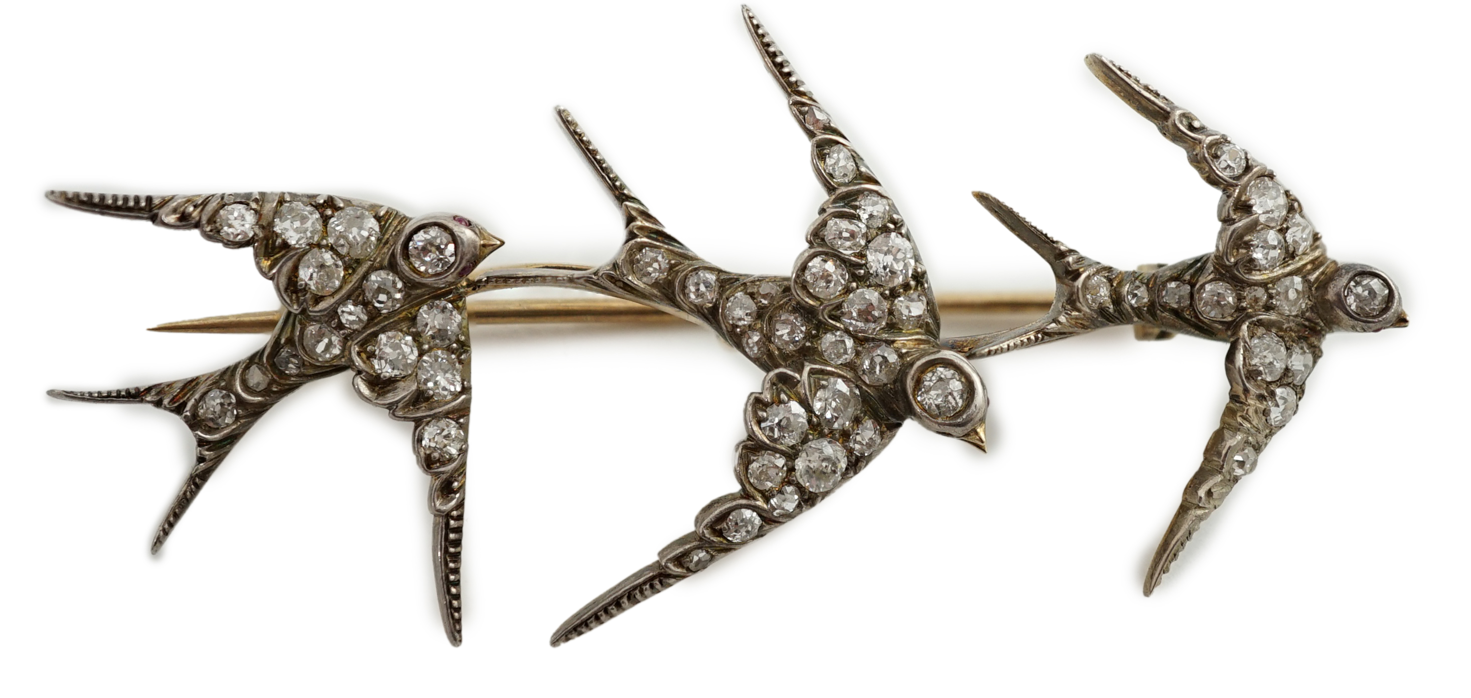 An Edwardian gold and graduated diamond cluster set triple swallow bar brooch